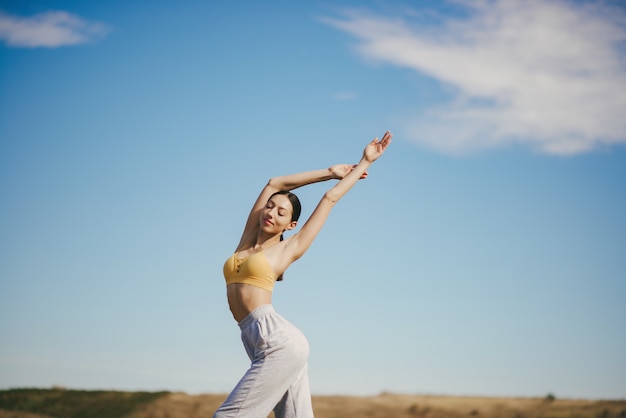 Cute girl training on blue sky