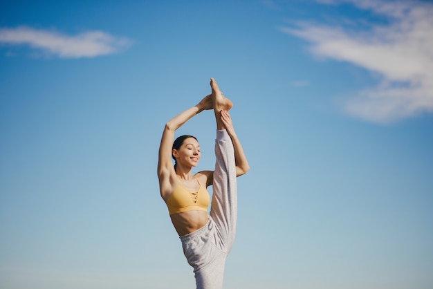 Cute girl training on blue sky