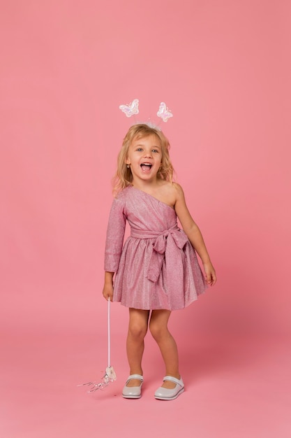 Free photo cute girl with fairy costume and wand in her hand