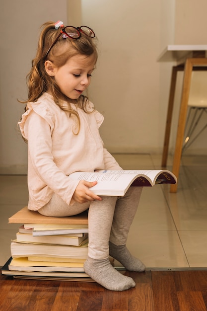 Cute girl with glasses reading book