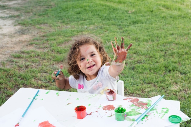 Free photo cute girl with hands painted in colorful paints