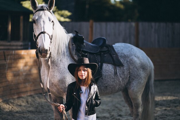 Cute girl with horse at ranch