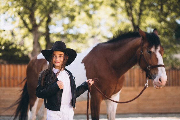 Cute girl with horse at ranch