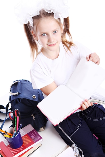 Free Photo cute girl with schoolbag sitting on the desk