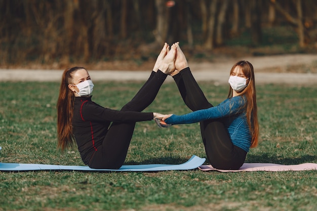 Free photo cute girls doing yoga in a masks