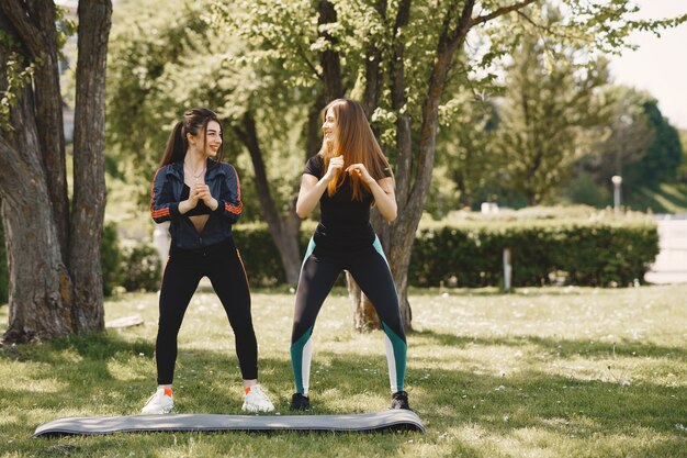 Cute girls doing yoga in a summer park