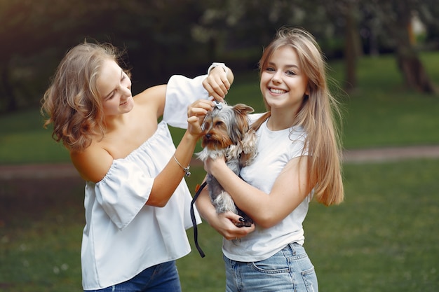 cute girls in a park playing with little dog