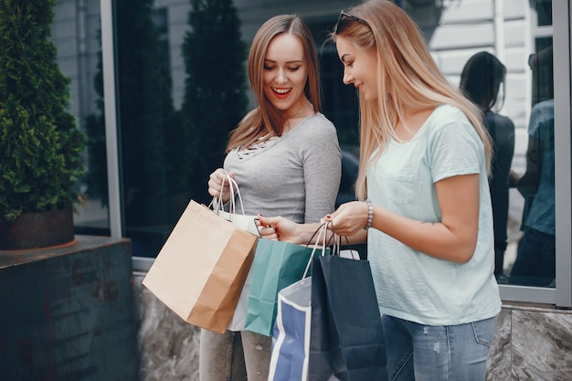 Free photo cute girls with shopping bag in a city