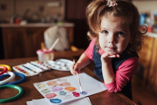 Free photo cute happy little girl, adorable preschooler, painting with wate