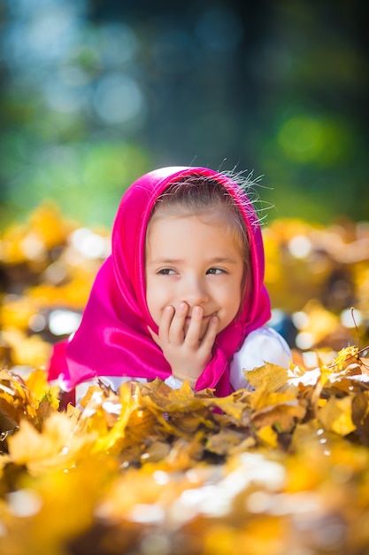 Free photo cute kid girl in a pink shawl and dress, a white jacket like masha and the bear from the cartoon.