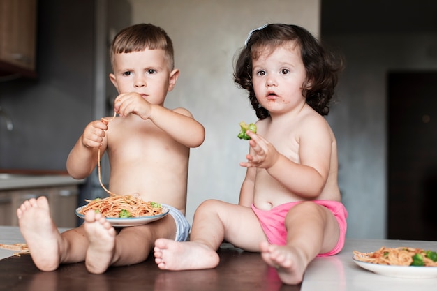 Cute kids sitting on the table and looking away