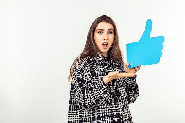 Free photo cute lady holding thumb up sign and point hand at it