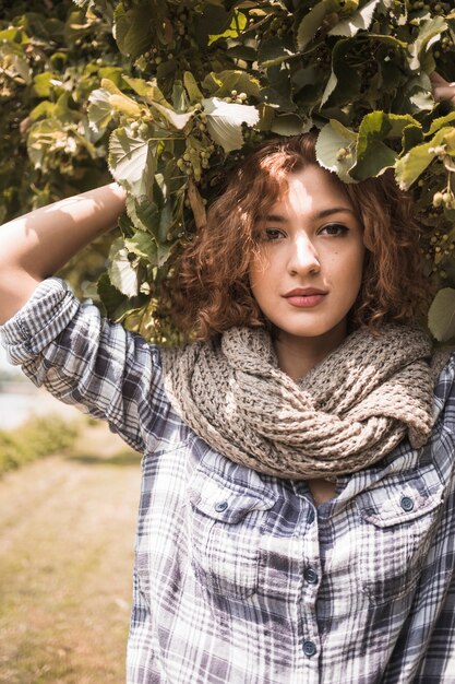 Cute lady in scarf under tree