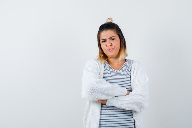 Free photo cute lady in t-shirt, cardigan holding arms folded and looking displeased , front view.