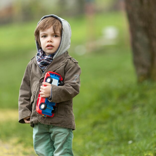 Cute little boy holding toy car