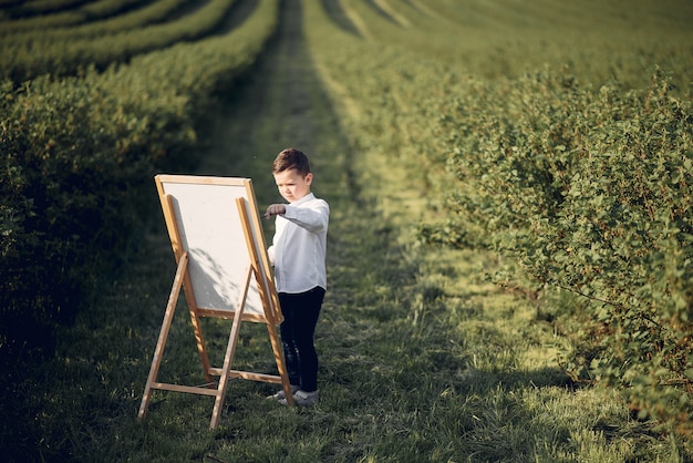 Cute little boy painting in a park