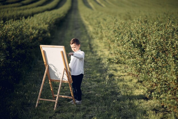 Cute little boy painting in a park