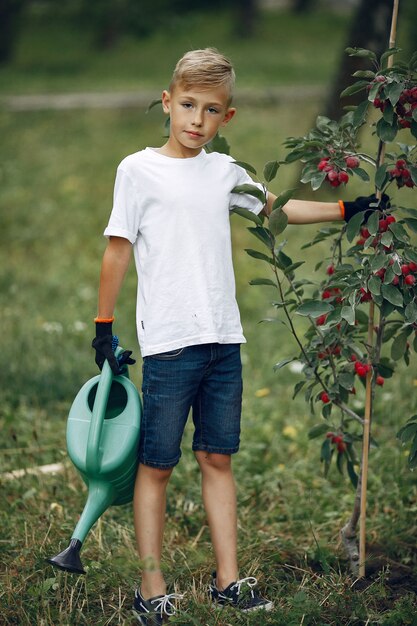 Cute little boy planting a tree on a park