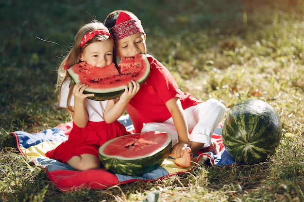 Cute little children with watermelons in a park