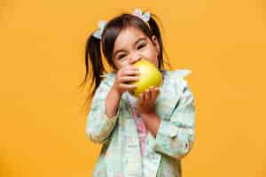 Free photo cute little girl child eating apple.