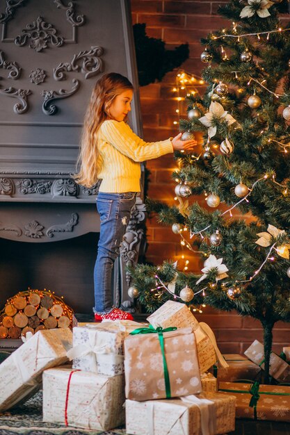 Cute little girl decorating christmas tree