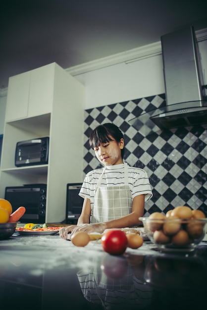 Free photo cute little girl kneads flour dough preparing for make pizza. cooking concept.