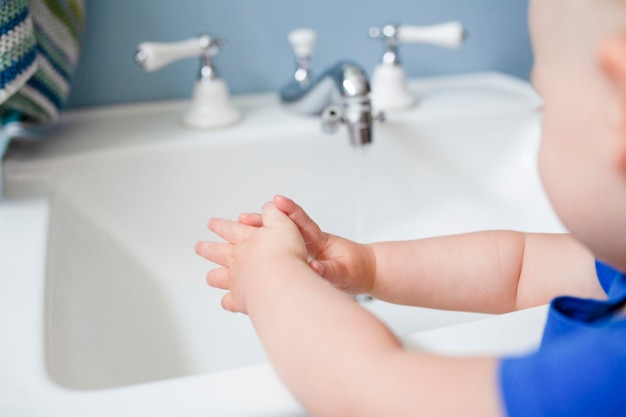 Free photo cute little girl learning how to wash her hands in the new normal