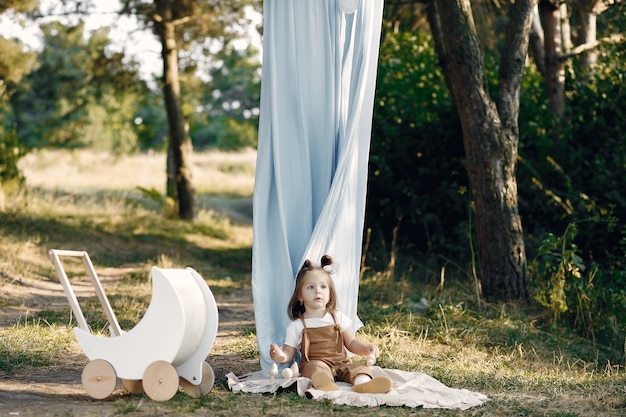 Cute little girl playing in a park with white carriage