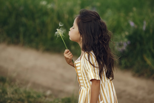 Free photo cute little girl playing in a summer field