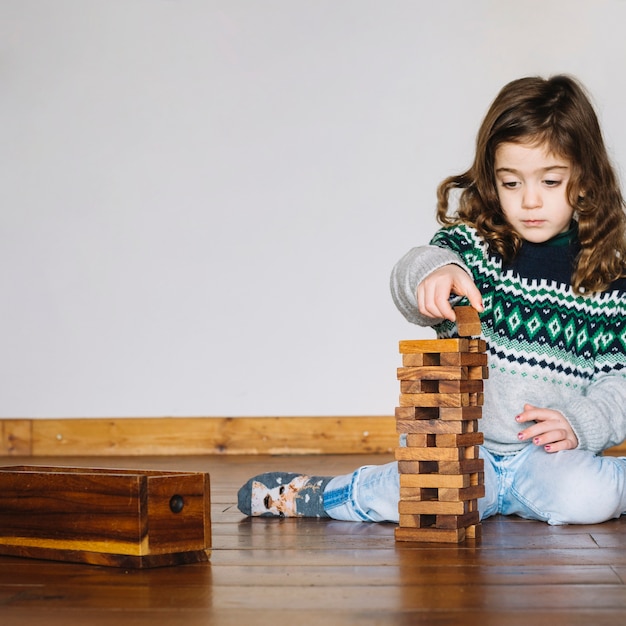 Free photo cute little girl playing wooden block game