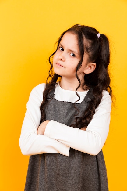 Cute little girl portrait posing on yellow background