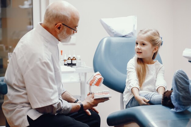 Cute little girl sitting in the dentist's office