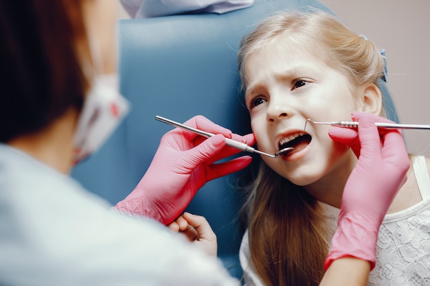 Cute little girl sitting in the dentist's office