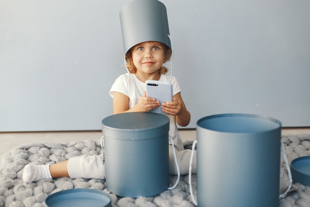 Free photo cute little girl sitting in a studio with presents box