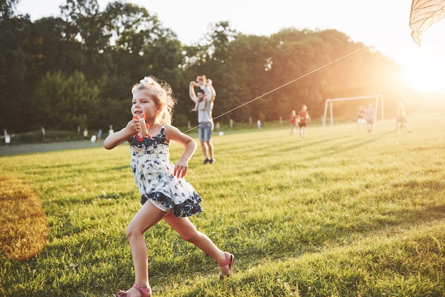 Free Photo cute little girl with long hair running with kite in the field on summer sunny day