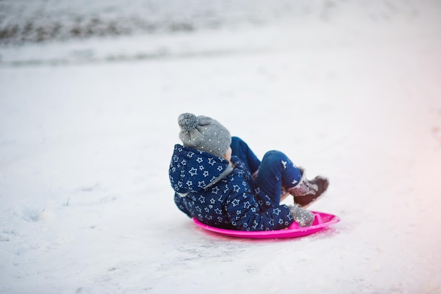 Free photo cute little girl with saucer sleds outdoors on winter day