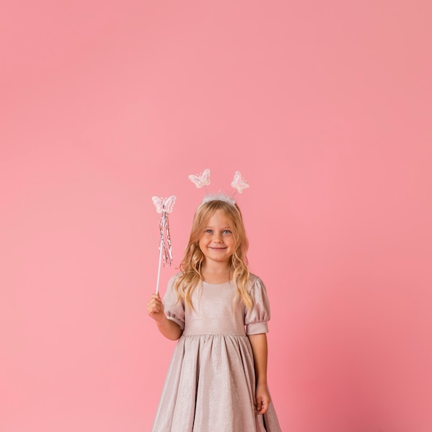 Free photo cute little girl with wand and copy space