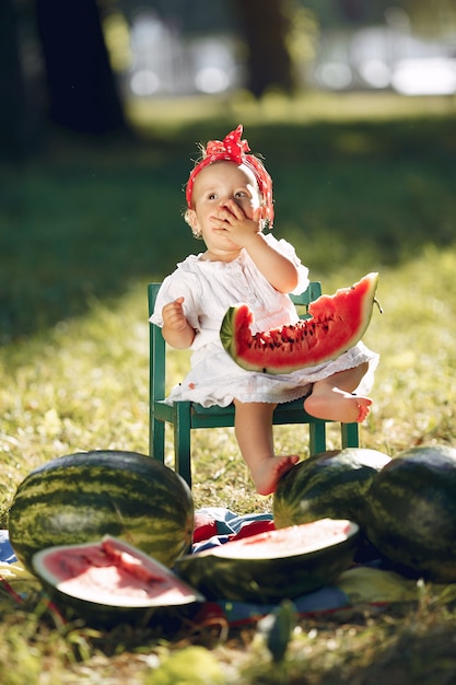 Free Photo cute little girl with watermelons in a park