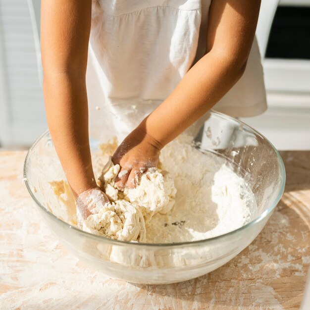 Cute little hands preparing dough