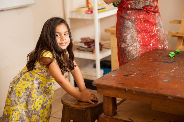 Free Photo cute little hyperactive girl standing up and moving around during art class