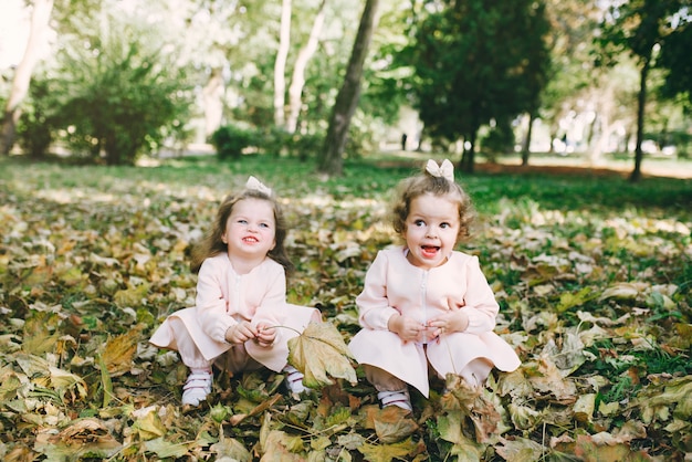 Free photo cute little sisters playing  in a spring park