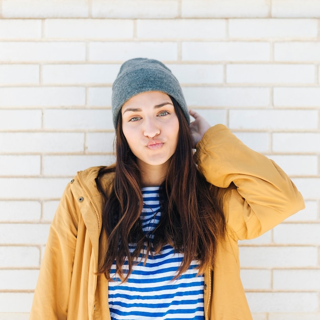 cute lovely woman in casual outfit pouting her lips looking at camera