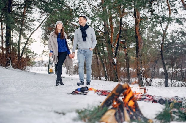 Free photo cute and loving couple in a winter forest