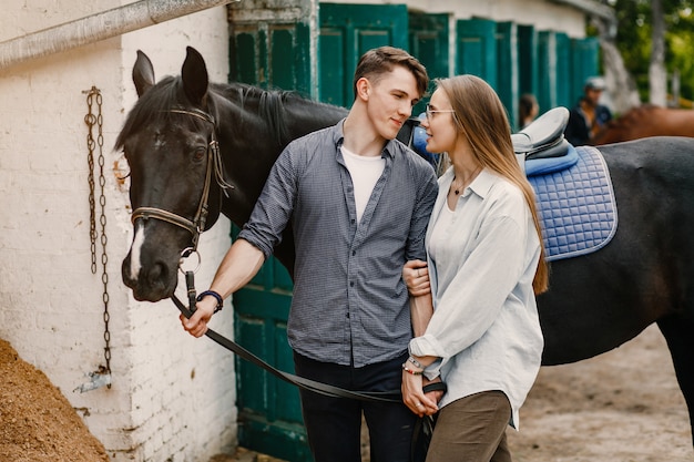 Cute loving couple with horse on ranch