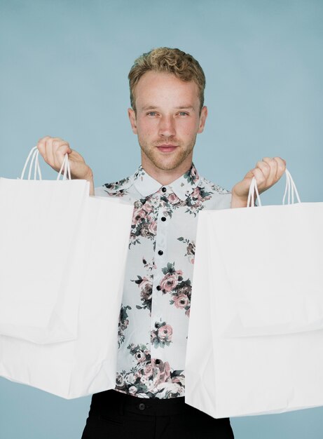 Cute man with shopping bags looking at camera