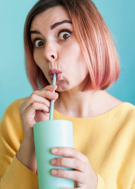 Cute model sipping drink front view