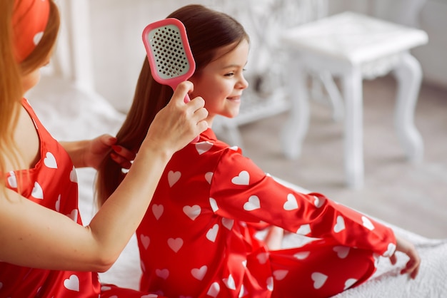 Free photo cute mother and daughter at home in a pajamas