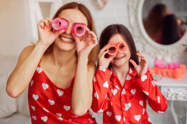 Free photo cute mother and daughter at home in a pajamas