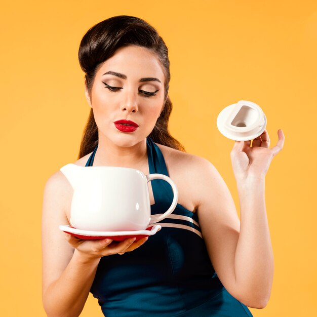 Cute pinup girl holding a teapot