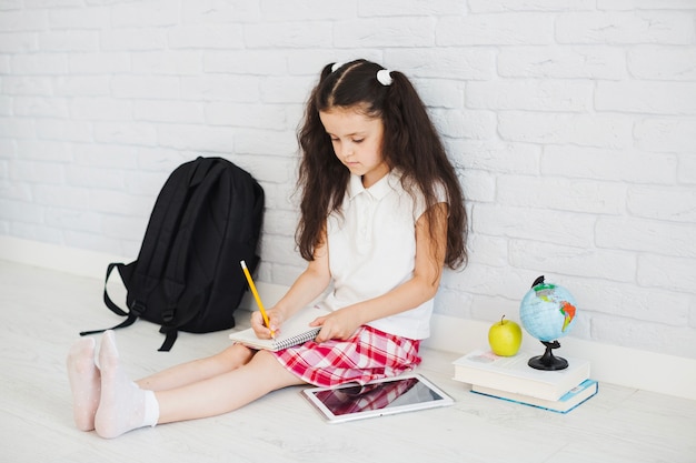 Cute pupil girl writing